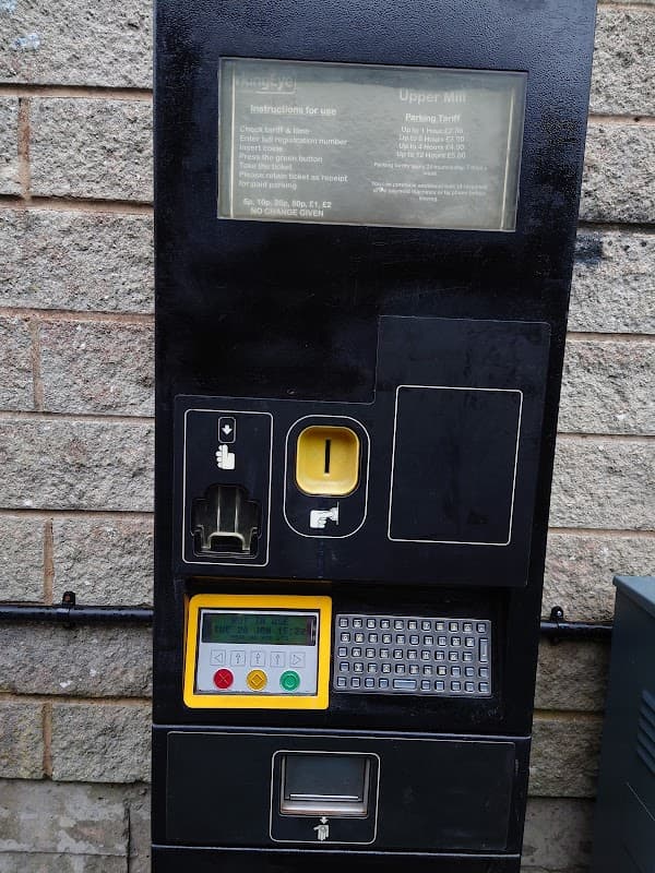 Pay & Display parking machine with instructions, coin slot, and keypad, set against a stone wall in Slaithwaite Mills Carpark.