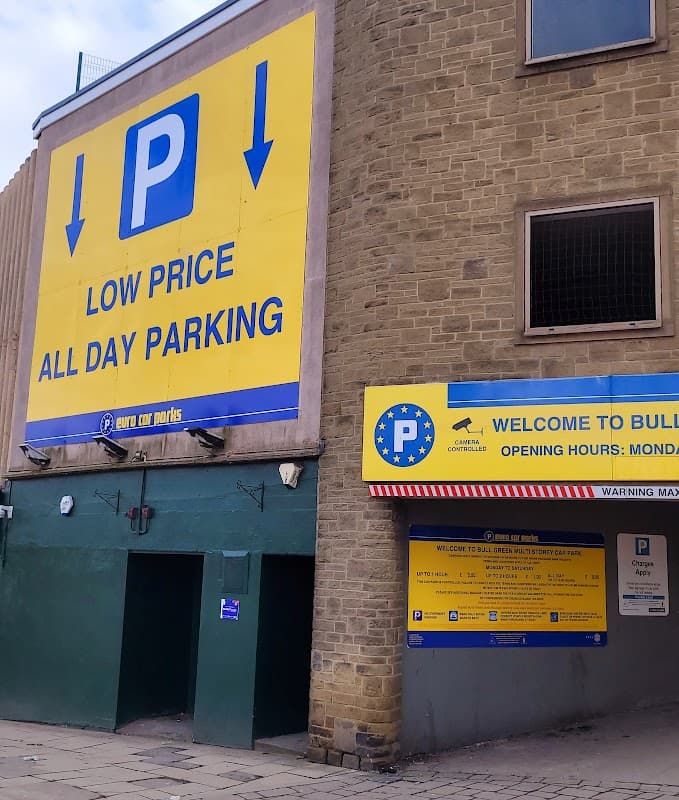 Bright yellow signage for Euro Car Parks, featuring parking symbols, opening hours, and a low price message.