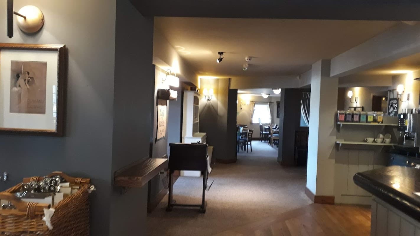 Interior of Owl Hotel featuring a cozy bar area, wooden furniture, and warm lighting in a welcoming atmosphere.