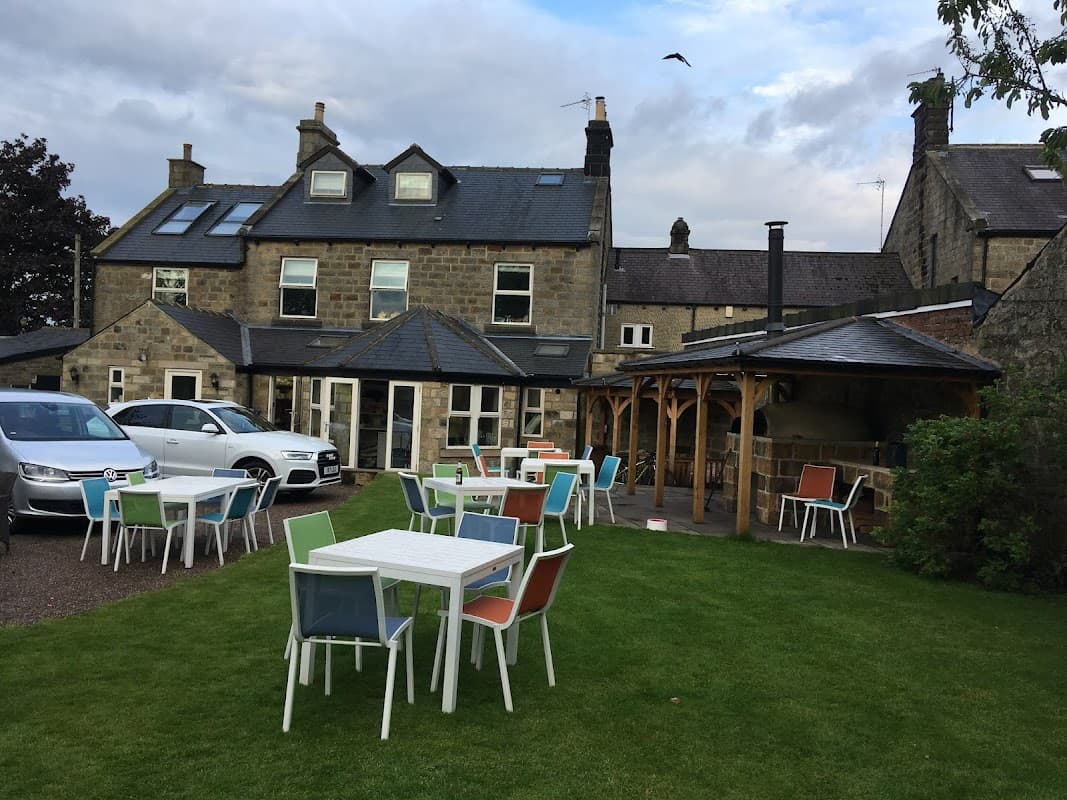Charming outdoor seating area with colorful chairs, surrounded by a stone building and lush green lawn in Hampsthwaite.