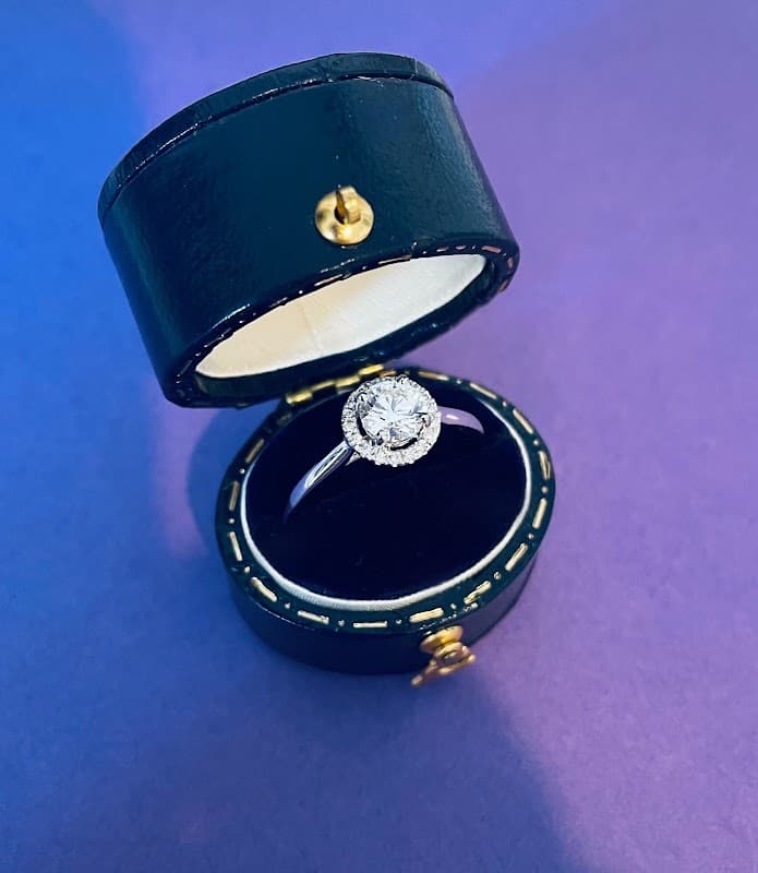 A sparkling diamond ring displayed in a black velvet-lined jewelry box.
