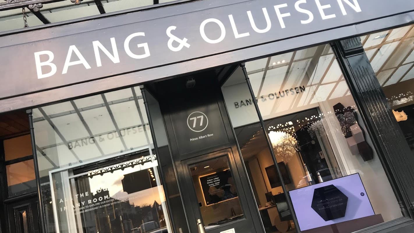 Bang & Olufsen storefront with large signage, glass windows, and modern display screen.