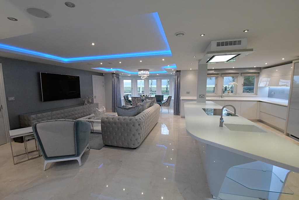 Modern interior featuring sleek furniture, LED lighting, and a spacious open layout with a stylish kitchen and living area.