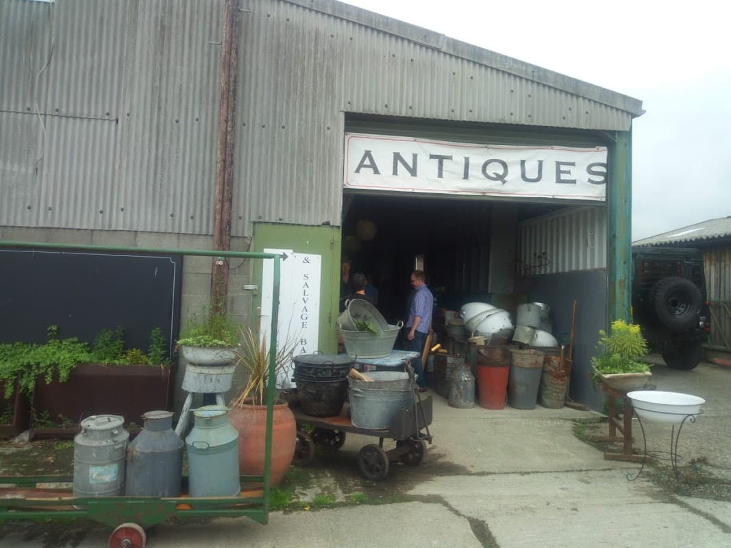 Entrance to Castleforge Antiques Ltd with various vintage items and planters outside, set in a rustic building.