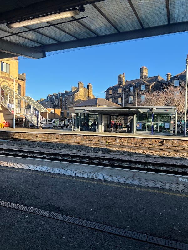 Pay & Display car park at Harrogate Station, with buildings and clear blue sky in the background.