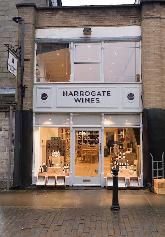 Exterior of Harrogate Wines with large windows, wooden display cases, and a sign featuring the name prominently.