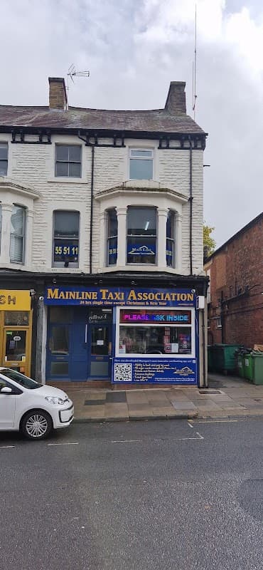 Mainline Taxi Association storefront in Harrogate, featuring blue signage and large windows on a two-story building.