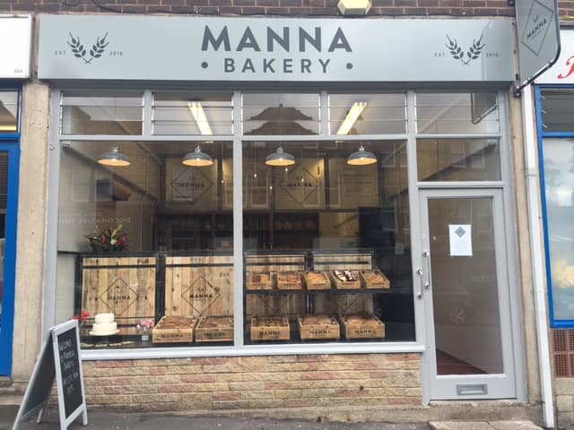 Charming bakery storefront with wooden crates, a cake display, and a sign reading "Manna Bakery" in Harrogate, Yorkshire.