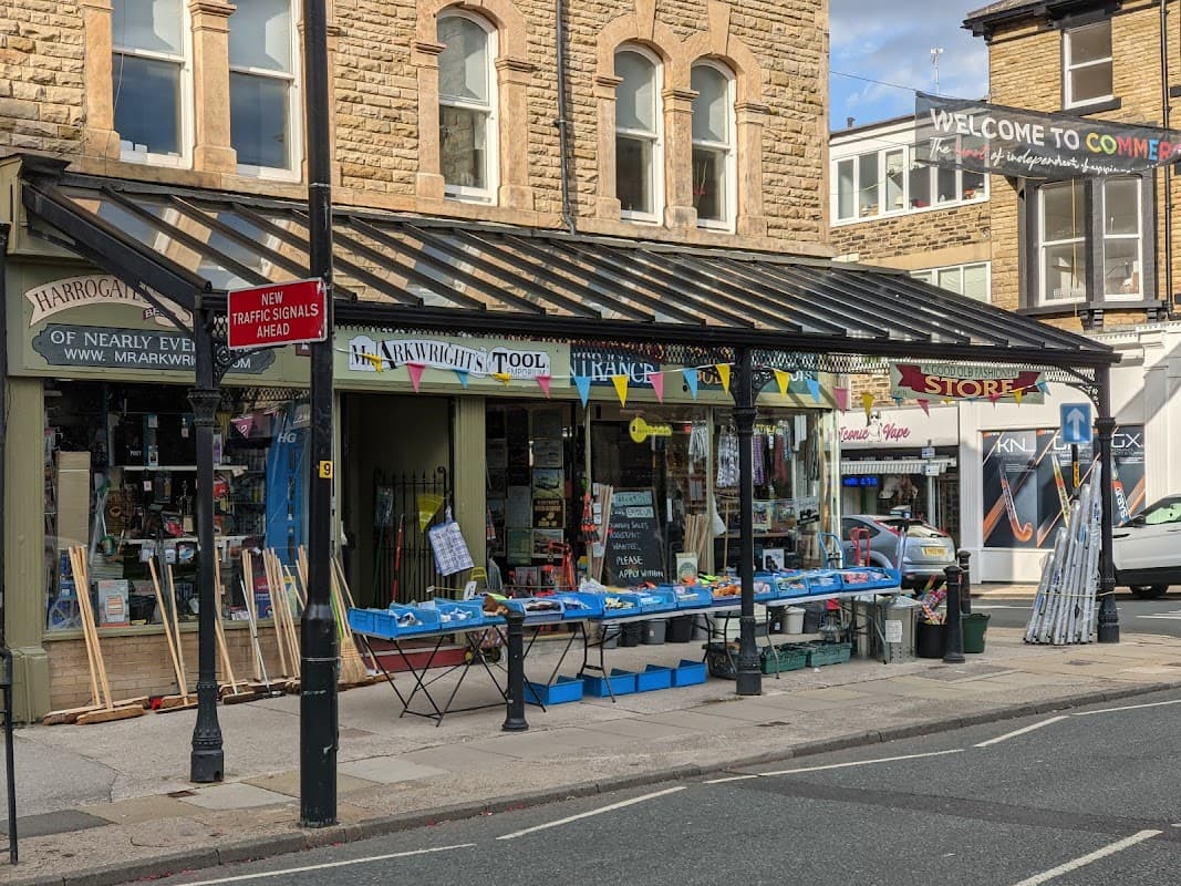 Mr Arkwright's Tool Emporium storefront with colorful signage, tools displayed outside, and a welcoming banner overhead.