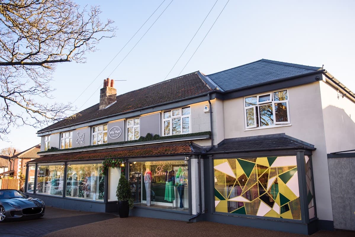 Department store exterior with large windows showcasing colorful dresses and modern geometric patterns.