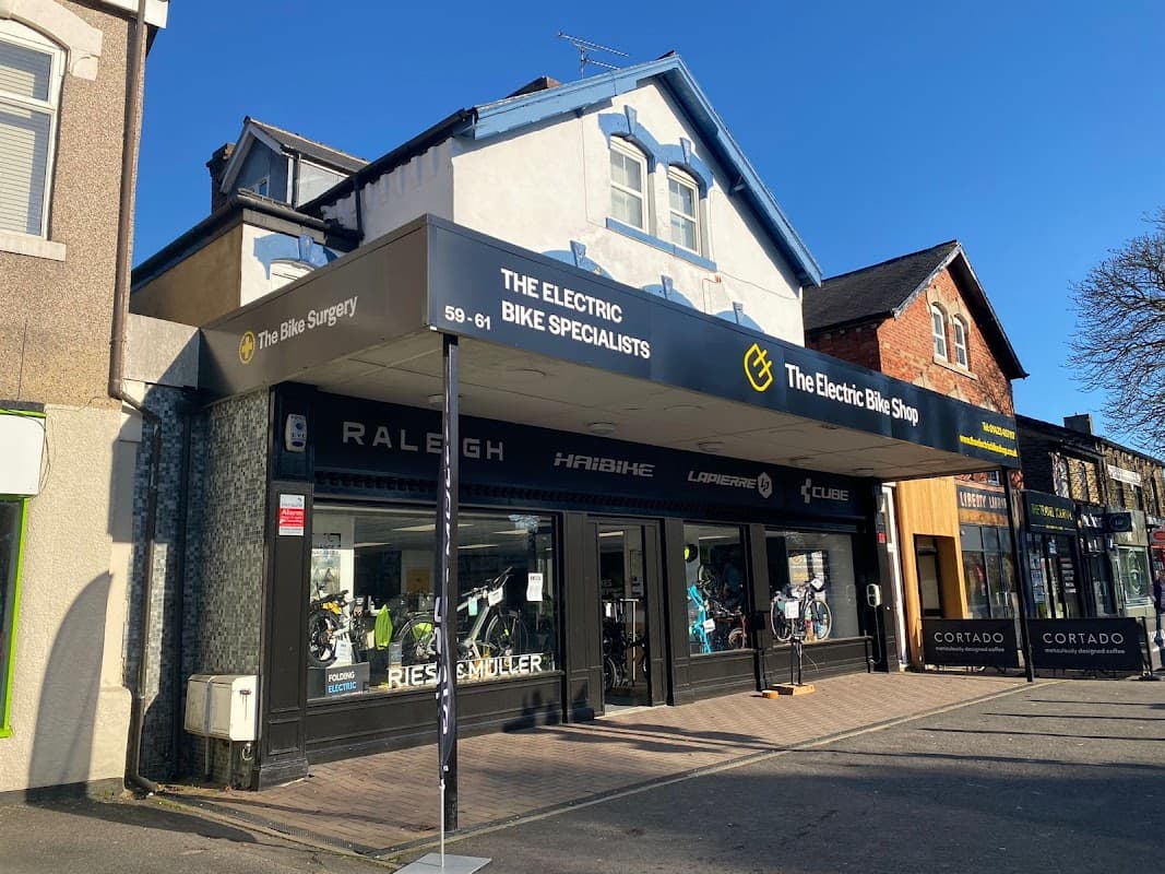 The Electric Bike Shop storefront features bikes displayed in windows and a sign indicating "The Electric Bike Specialists."