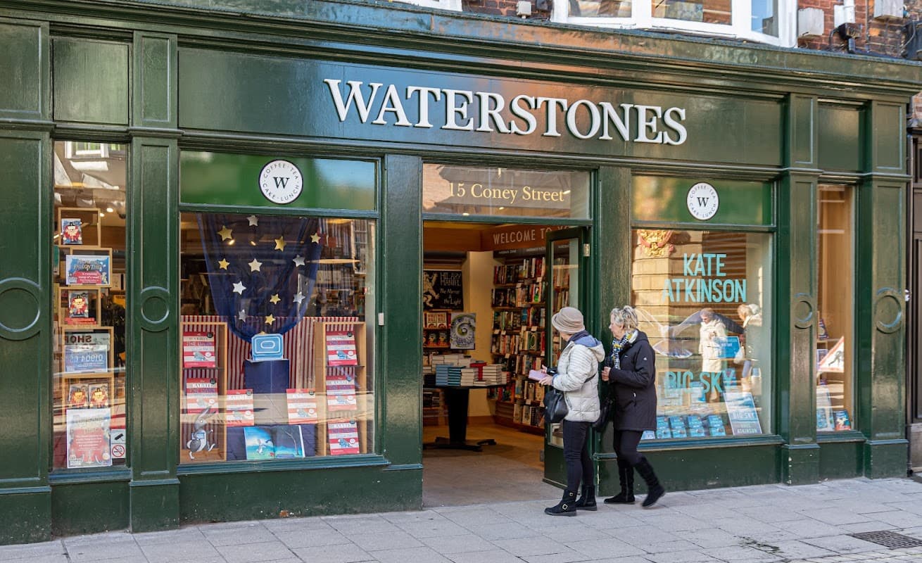 Waterstones bookstore in Harrogate, featuring a green facade, welcoming entrance, and display of books in windows.
