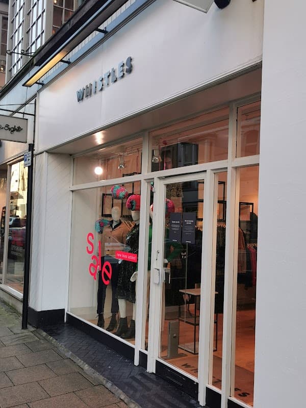 Clothing shop entrance with mannequins, sale sign, and modern window display in Harrogate, Yorkshire.