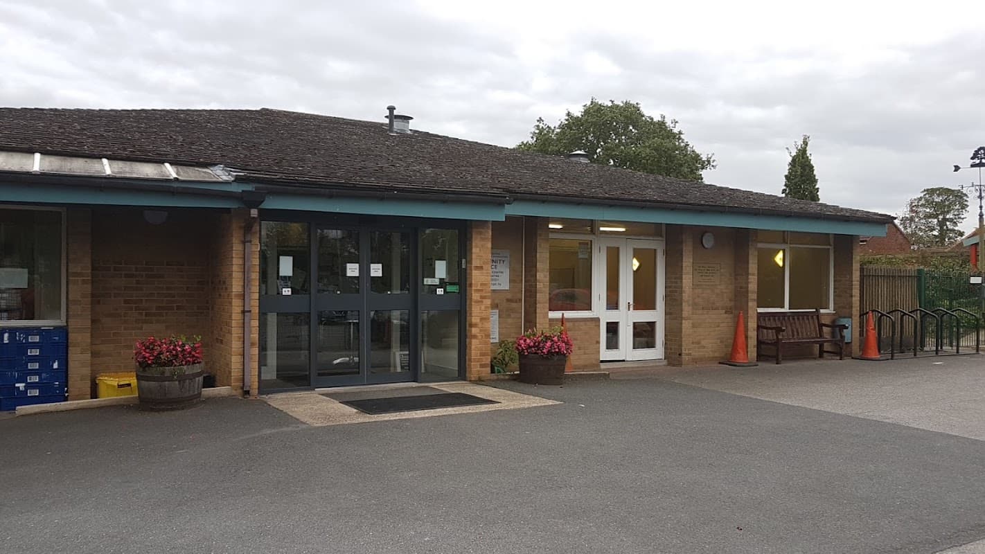 Entrance of Oaken Grove Community Centre featuring double doors, planters, benches, and a paved area.