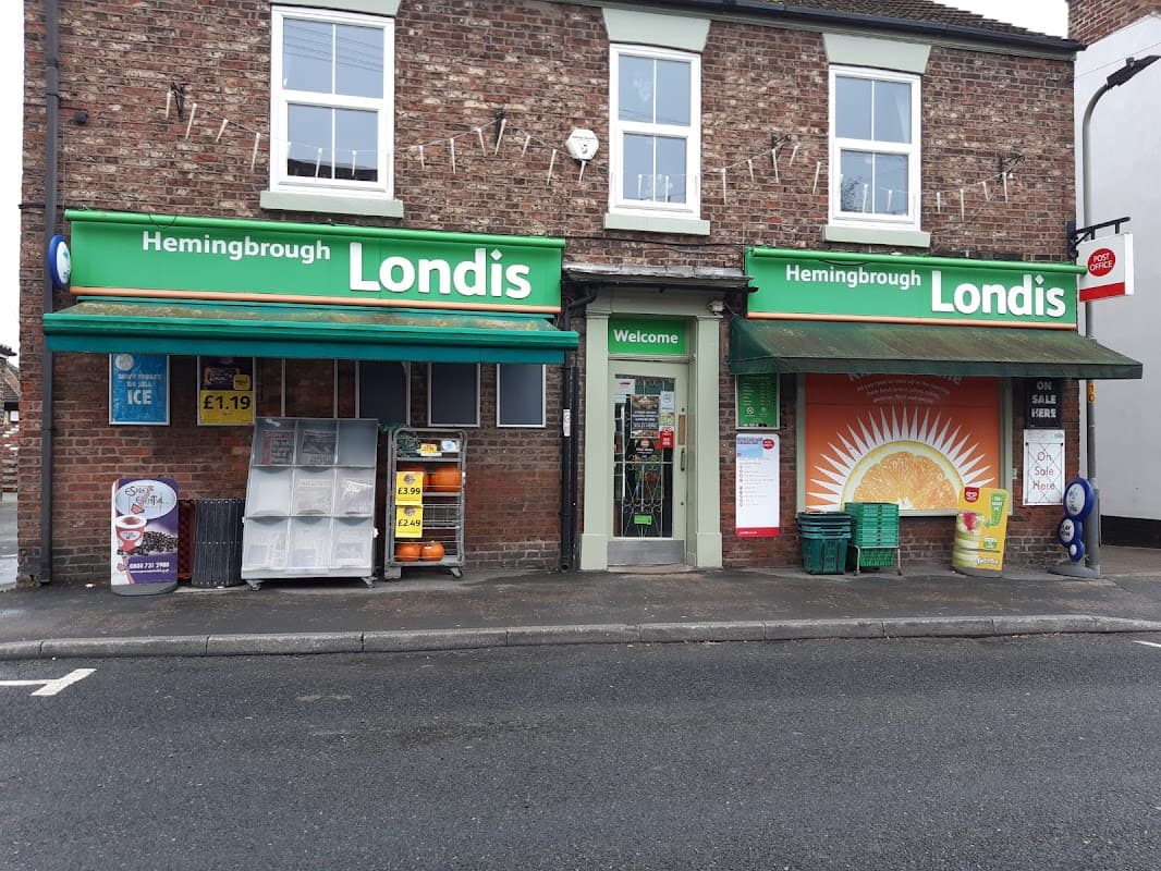 Hemingbrough Londis storefront with green signage, ice cream display, and orange sun mural on the wall.