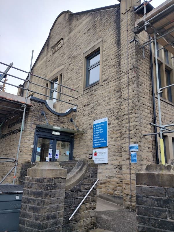 Stone building with scaffolding, entrance steps, and signage for Holme Valley Memorial Hospital in Yorkshire.