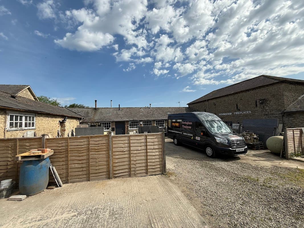 Hovingham Fireplaces & Stoves shop with a delivery van, stone buildings, and a clear blue sky in Yorkshire.