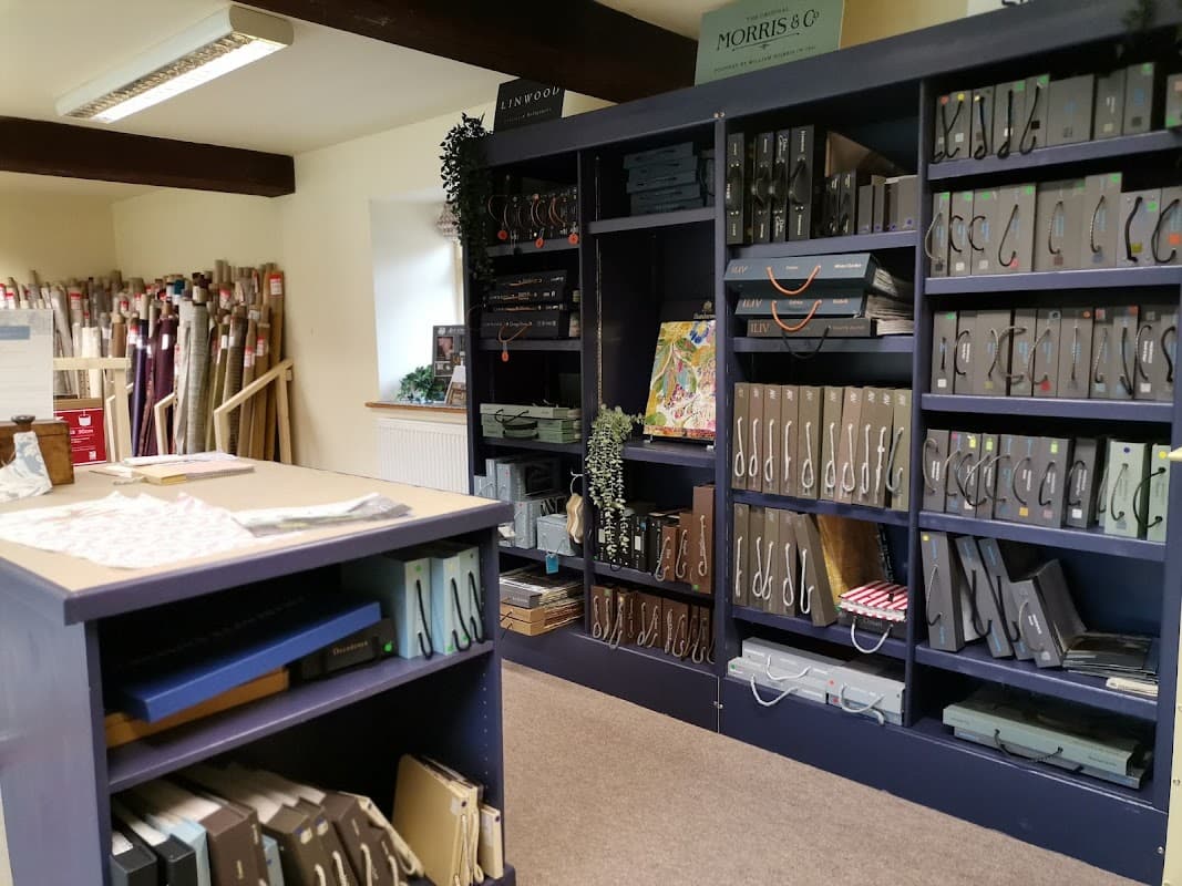 Interior of Wath Court Fabrics shop featuring shelves of fabric samples, swatches, and a display table.
