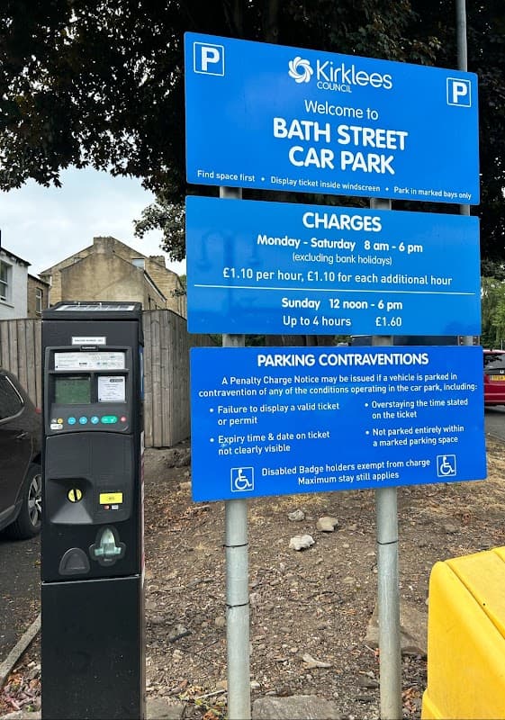 Welcome sign for Bath Street Car Park, with parking charges and payment machine visible. Trees in the background.