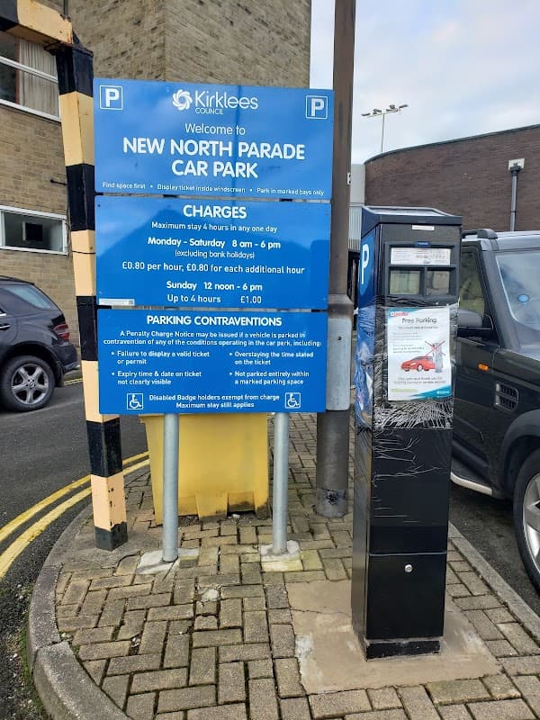 Sign for New North Parade Car Park with parking charges and hours, alongside a parking payment machine.