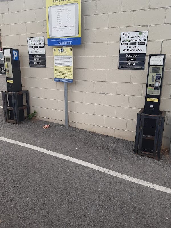 Pay and display parking machines next to signage in a car park in Huddersfield, Yorkshire.