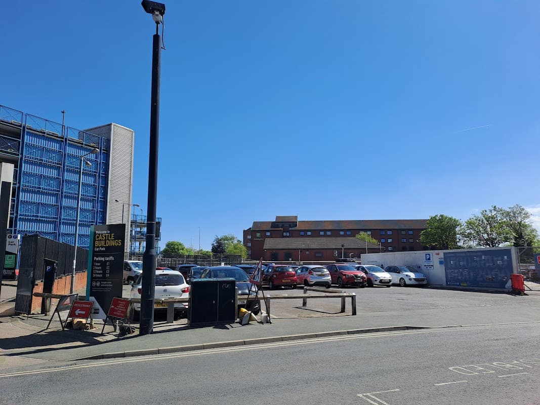 Castle Buildings Car Park with parked cars, clear blue sky, and nearby buildings in Hull, Yorkshire.