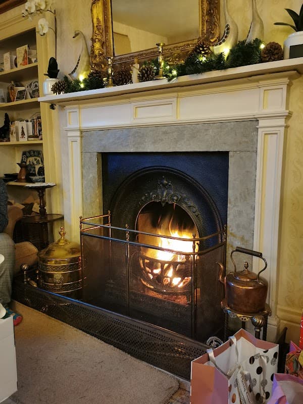 Cozy fireplace with a roaring fire, surrounded by decorative elements and a warm, inviting atmosphere.