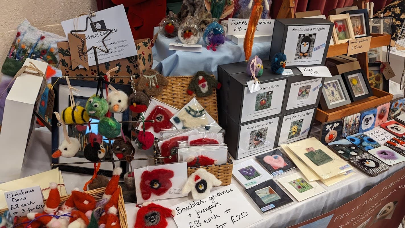 Craft stalls display colorful felted animals, handmade cards, and various crafts at Sheriff Hutton Village Market in Yorkshire.