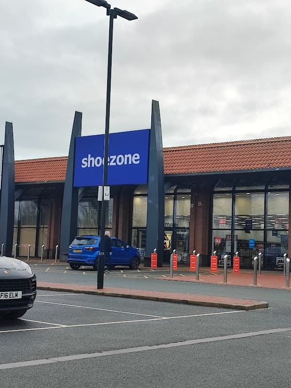 ShoeZone store with a blue sign, modern architecture, and parked cars in front, located in Keighley, Yorkshire.
