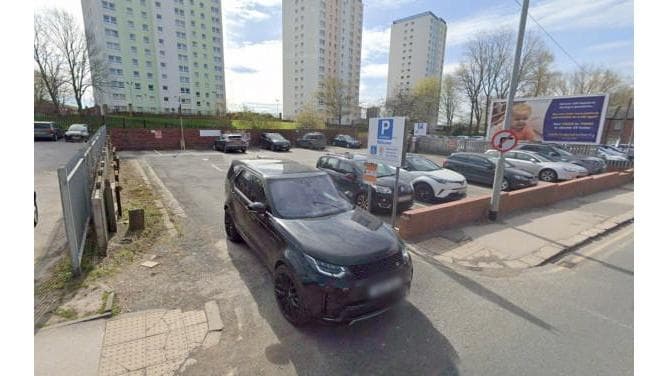 Pay & Display parking area in Killingbeck, Yorkshire, with multiple parked cars and high-rise buildings in the background.