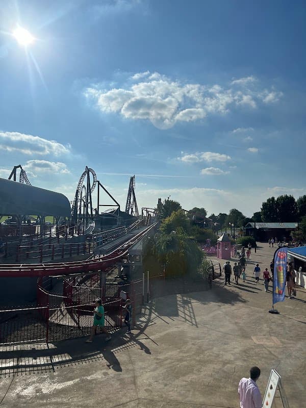 A sunny day at The Splash Zone, featuring roller coasters, visitors, and vibrant attractions at Flamingo Land Resort.
