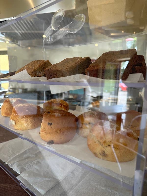 Brownies and scones displayed in a glass case at Wok Inn Ivy Bank, showcasing baked goods in a cozy setting.