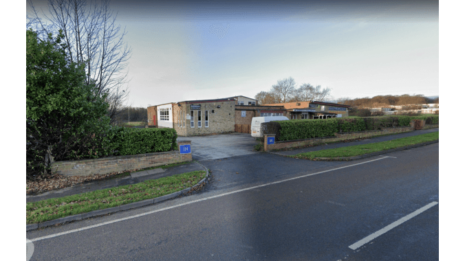Pay & Display parking area with a stone building and greenery in Kirkstall, Yorkshire.