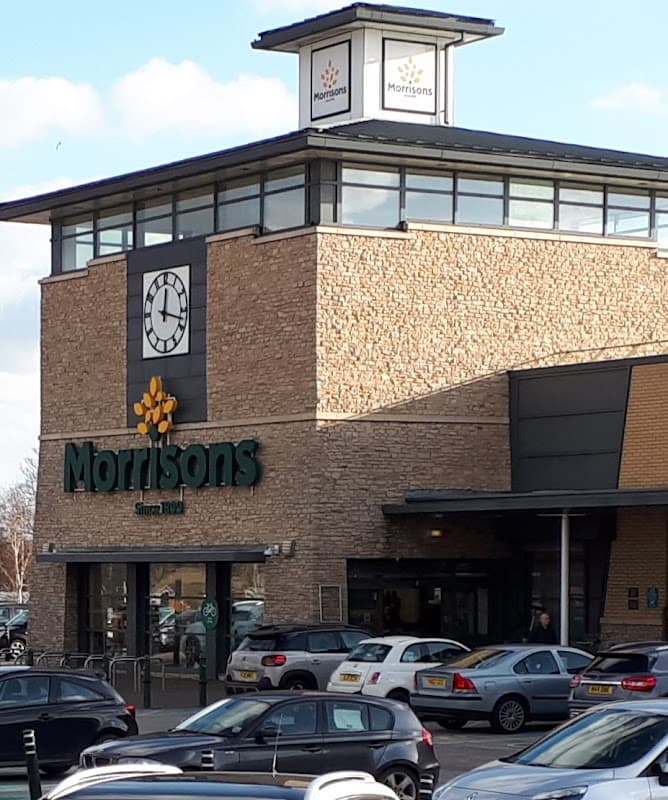 Morrisons store in Knottingley, Yorkshire, featuring a stone facade and a clock tower, with cars parked outside.