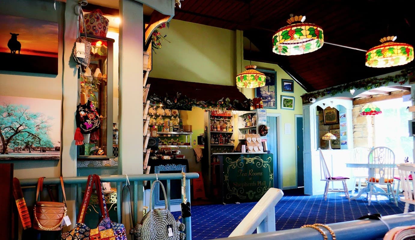 Quaint village shop interior with colorful lamps, shelves of goods, and decorative items in a cozy setting.