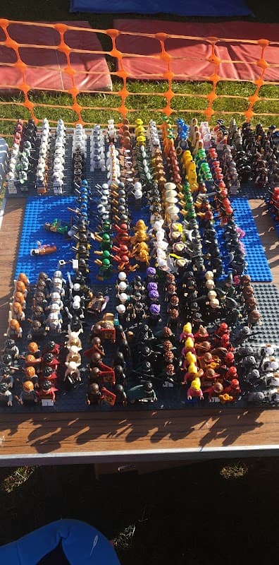 Colorful assortment of miniature figures arranged in rows on a blue surface at a market.
