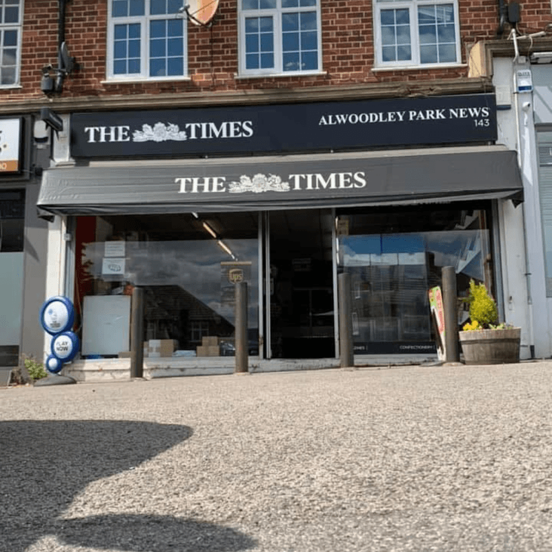 Alwoodley Park News shopfront with a black awning, displaying "THE TIMES," and a small flower planter outside.