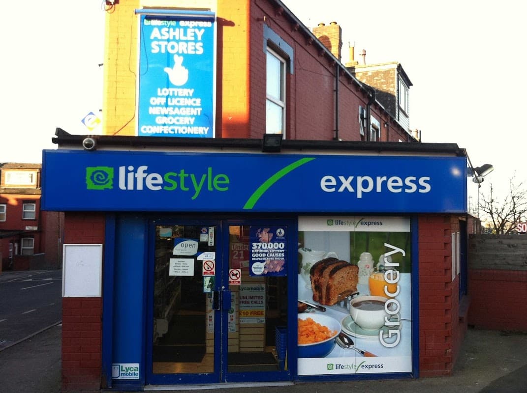 Bright blue storefront with "Lifestyle Express" signage, featuring grocery and confectionery offerings. Lottery and newsagent signs above.