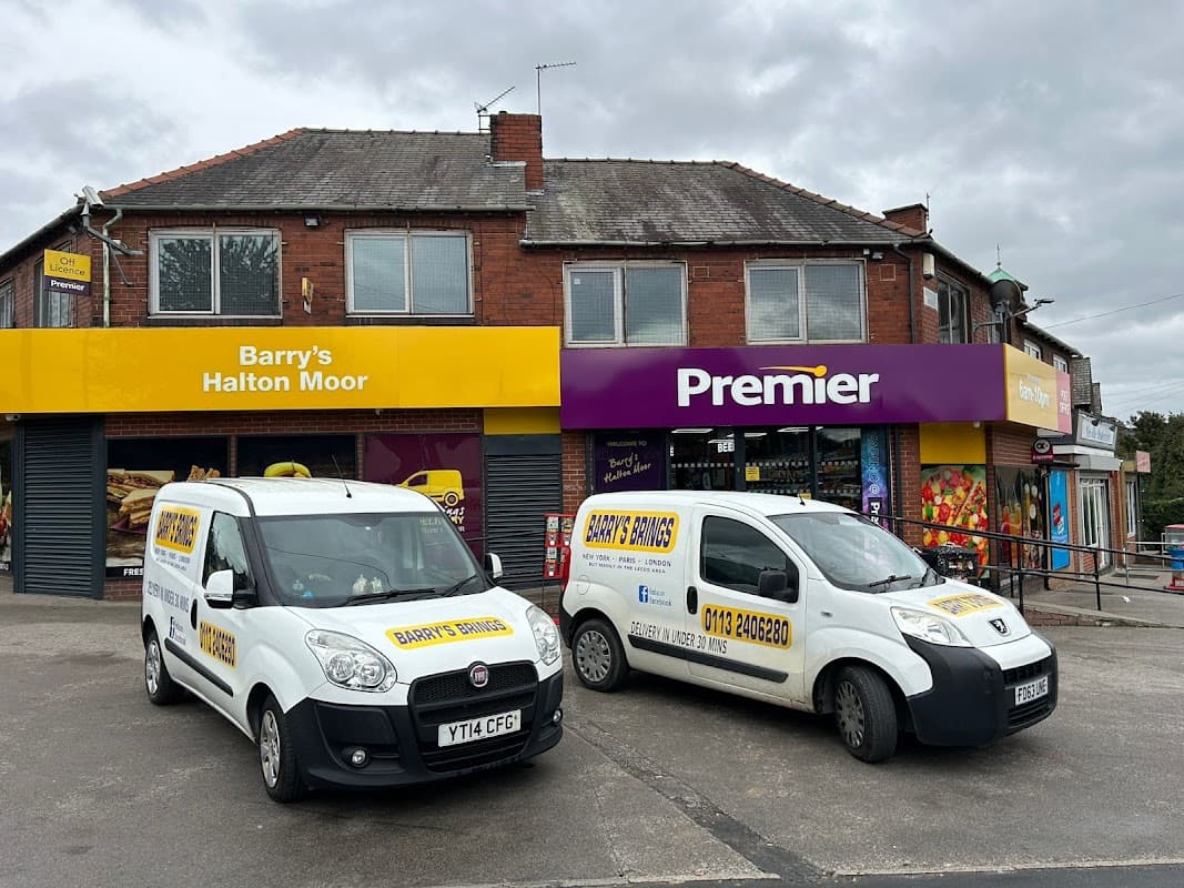 Two white vans parked outside a corner shop with yellow and purple signage reading "Barry's Halton Moor" and "Premier."