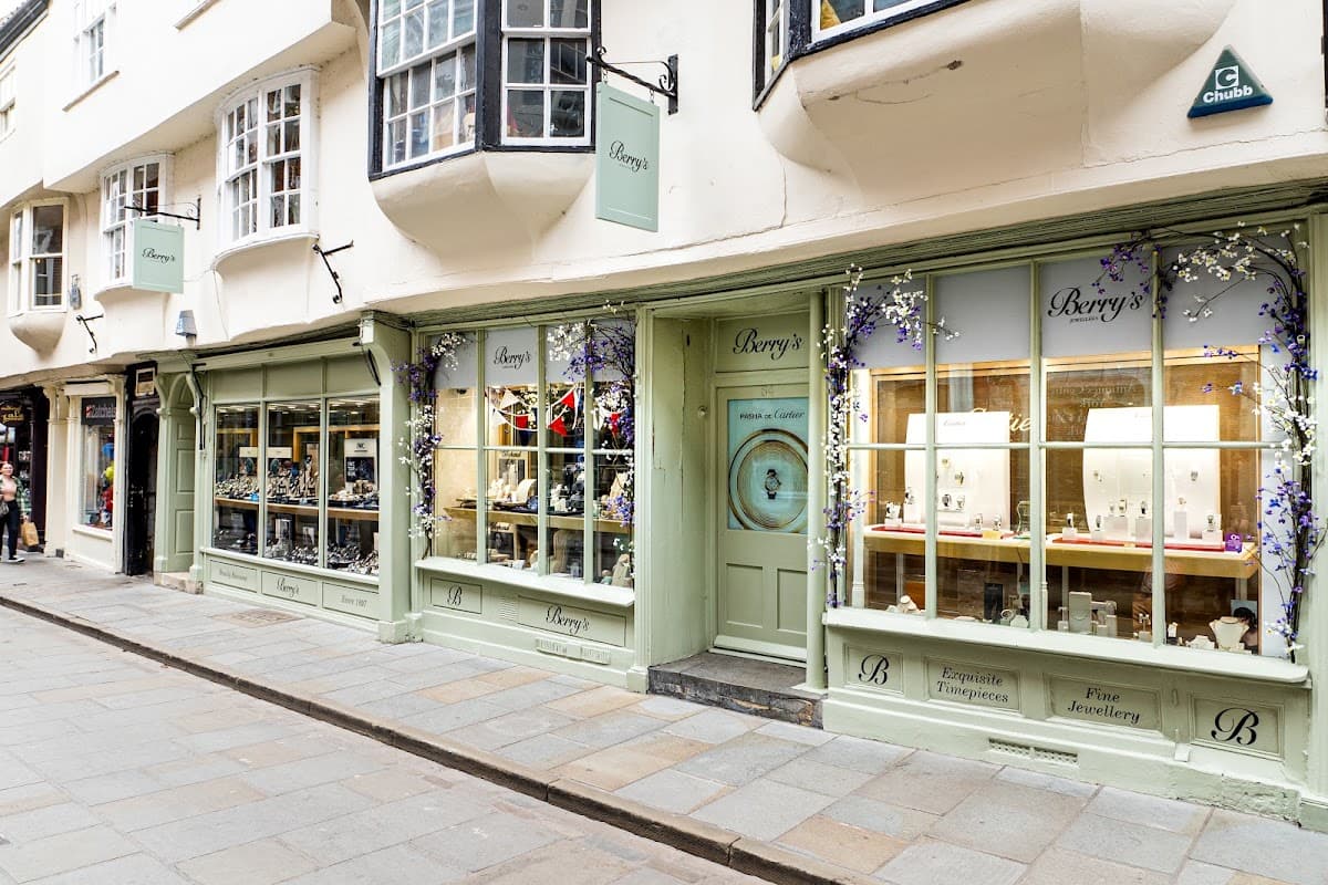 Quaint jewellers' shopfront with large windows displaying fine jewellery and floral decorations in Leeds, Yorkshire.