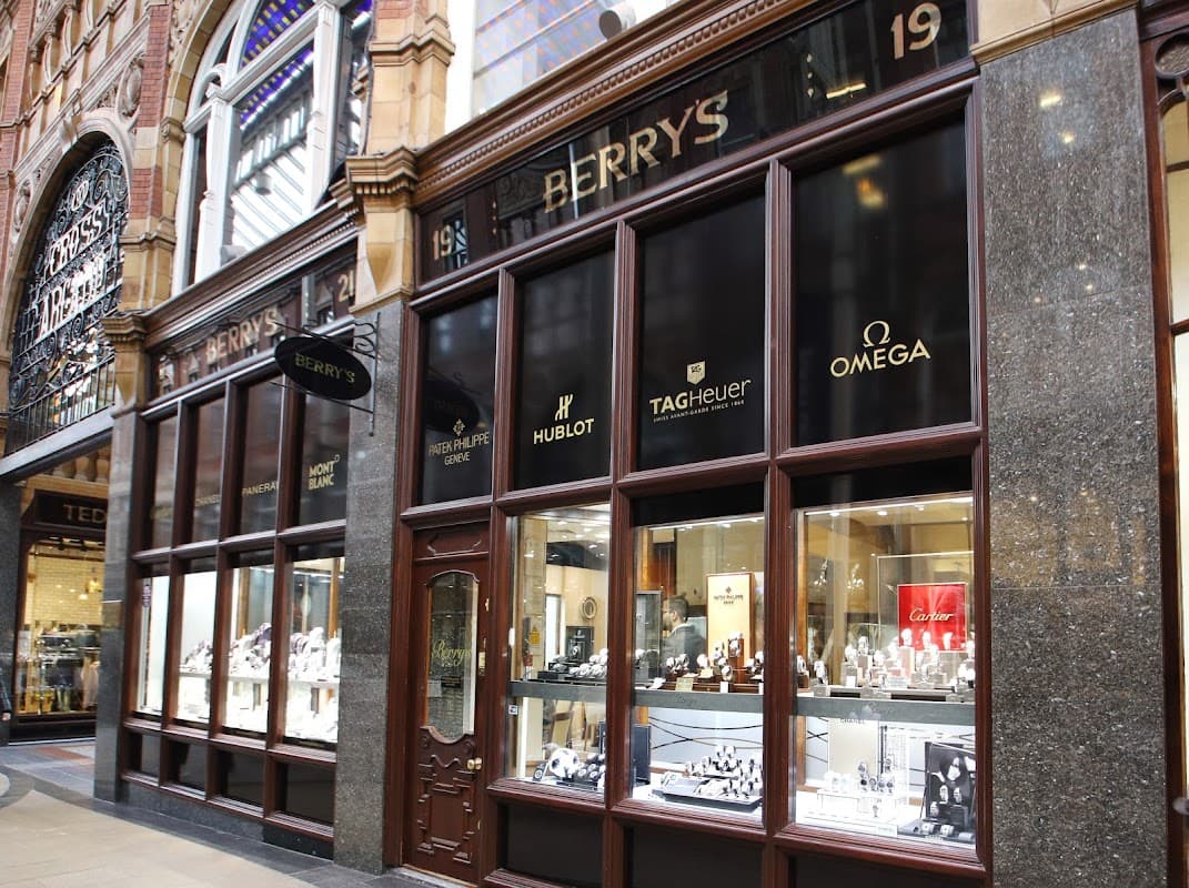 Elegant jewellers storefront featuring luxury brands like Hublot, TAG Heuer, and Omega in a historic arcade.