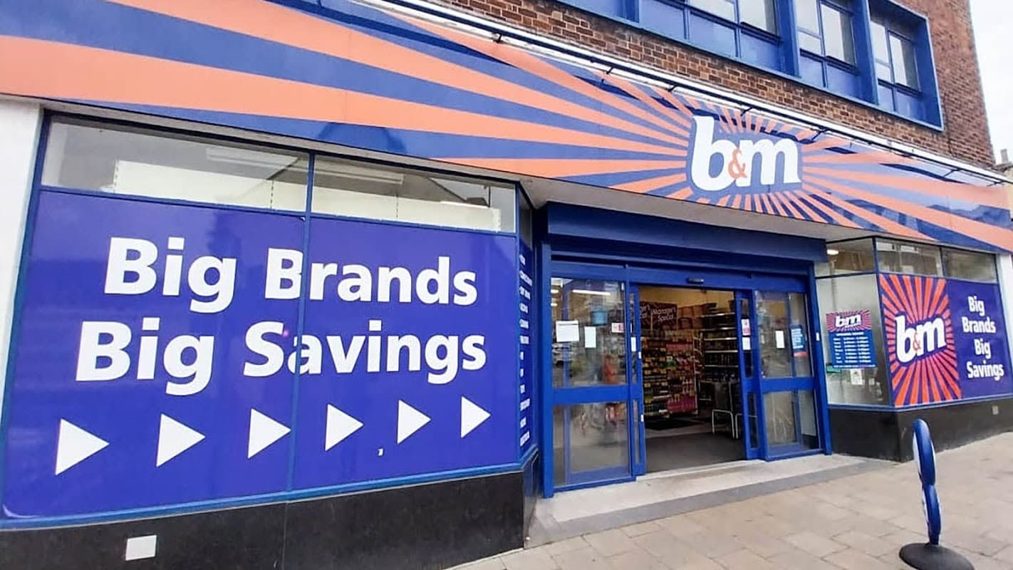 B&M Store in Leeds with blue and orange signage, displaying "Big Brands Big Savings" on large windows.