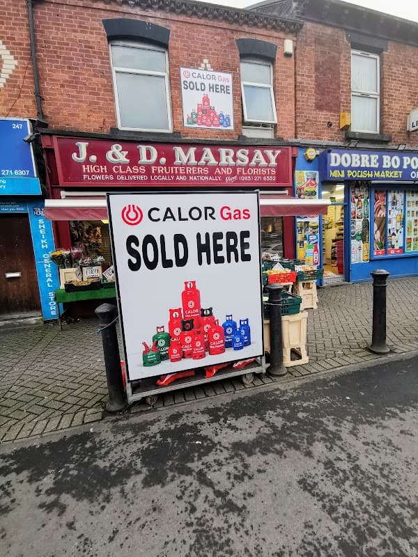 J & D Marsay Flowers storefront with a sign stating "CALOR Gas SOLD HERE" and colorful flower displays outside.