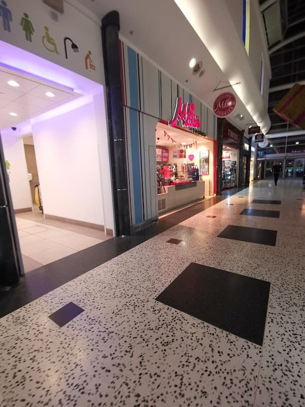 Millies Cookies shop with colorful signage in a shopping mall, featuring a bright interior and tiled flooring.