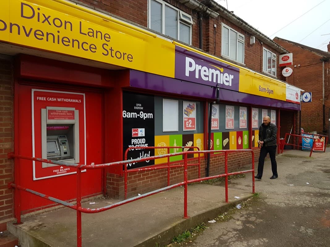 Premier Off Licence storefront with bright signage, ATM, and a man walking by in Leeds, Yorkshire.
