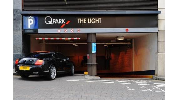 Entrance to Q-Park The Light in Leeds, featuring a black car and Pay & Display signage.
