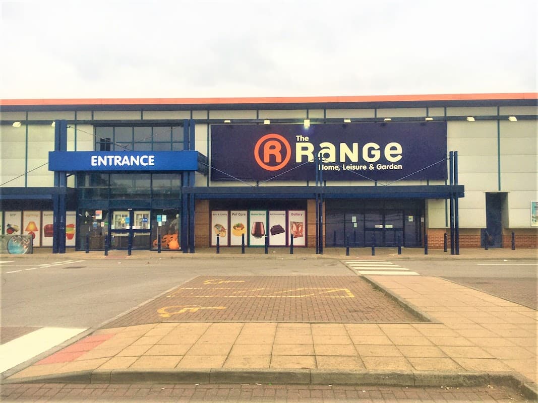 Storefront of The Range in Leeds, featuring a large sign, entrance, and parking area.