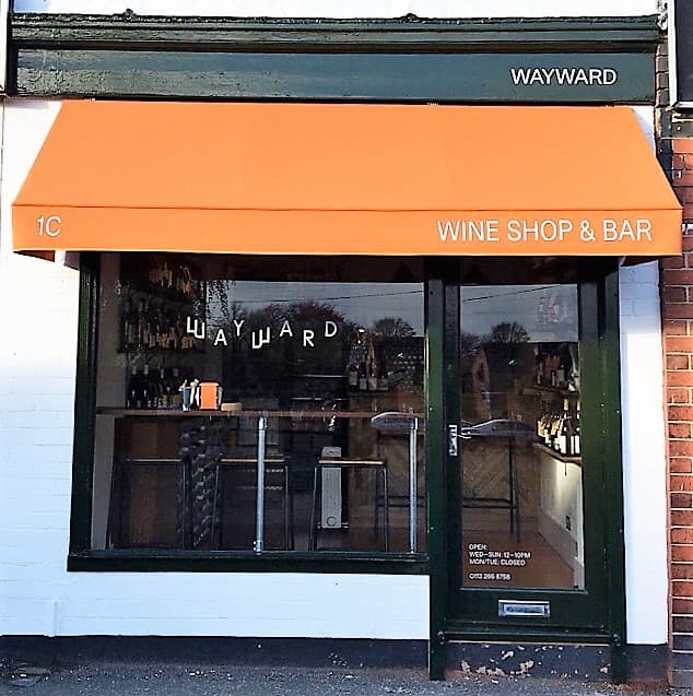 Wayward Wines shop front with an orange awning, displaying "WINE SHOP & BAR" and a welcoming entrance.