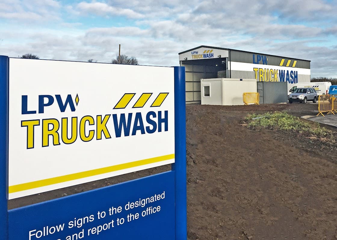 Sign for LPW Truckwash outside a modern service station building in Leeming Bar, Yorkshire, with cloudy skies above.