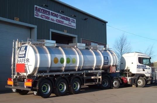 Sayers Road Tankers Ltd building with a tanker truck parked outside, featuring a silver tank and colorful dots.